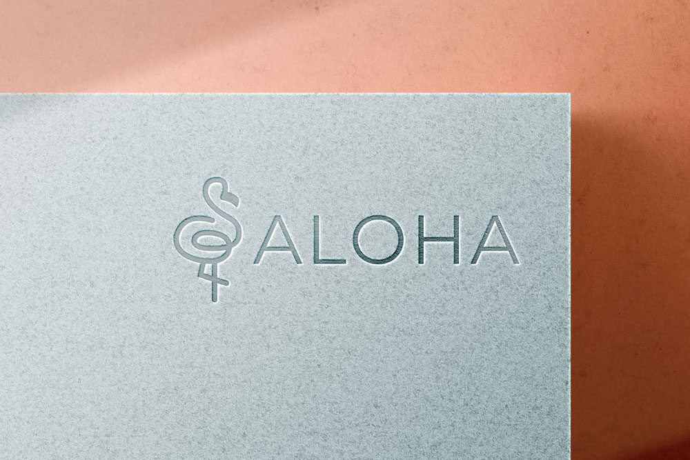 Logo Aloha inciso su una lastra di marmo appoggiato su sfondo arancione